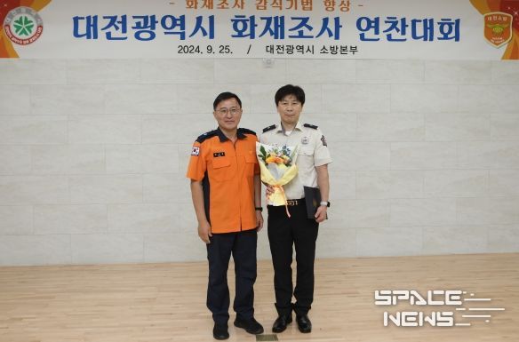 최우수상을 차지한 대전 대덕소방서 연구팀 정찬두 소방위가 수상 후 강대훈 소방본부장과 기념 촬영을 하고 있다.