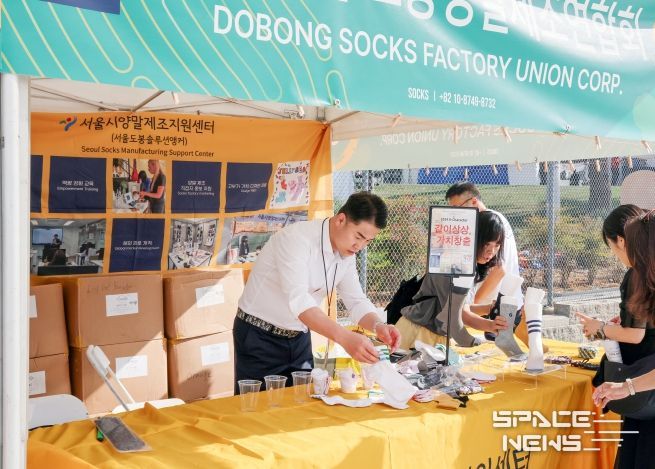 오언석 도봉구청장(가운데)이 LA한인축제에서 도봉구 양말 제품을 홍보하고 있다.