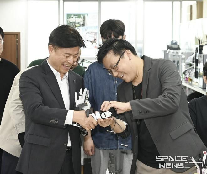 ㈜만드로의 이상호 대표가 조용익 부천시장에게 전자의수를 보여주고 있다.