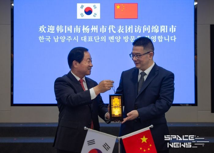 주광덕 남양주시장(좌)이 리원 몐양시장(우)에게 기념품을 전달하고 있다.