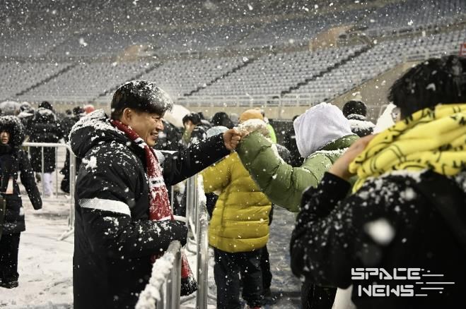 부천FC1995의 승강 PO 1차전이 폭설로 연기된 후 돌아가는 시민들과 조용익 부천시장이 주먹인사를 나누고 있다.