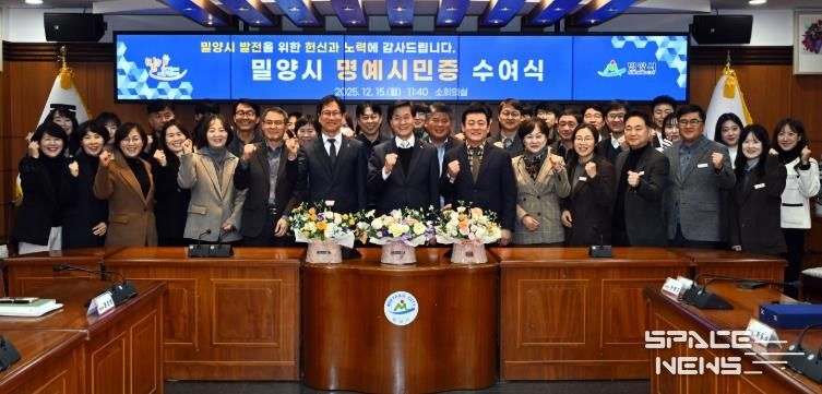 2: 15일 밀양시청 소회의실에서 열린 명예시민증 수여식 참석자들이 함께 기념 촬영을 하고 있다.