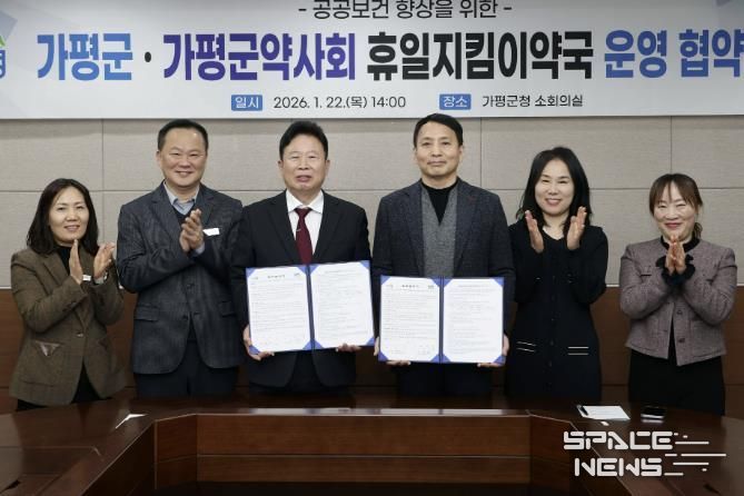 서태원 가평군수(사진 왼쪽에서 세번째)와 안병현 가평군약사회 회장(〃 네번째) 등이 22일 휴일지킴이약국 운영 협약식 후 협약서를 보이며 기념촬영을 하고 있다.