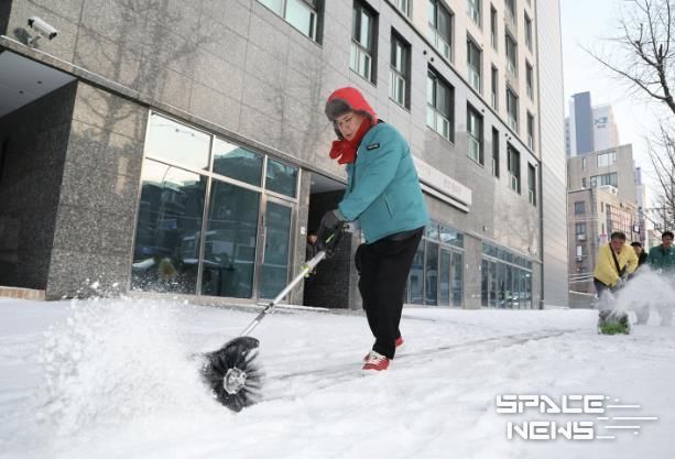 박강수 마포구청장이 공덕동 만리재로 일대에서 전동식 제설장비를 활용해 보도 제설작업을 하고 있다.